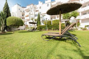 una silla con sombrilla en un patio en Apartamento Pueblo Quinta, en Benalmádena