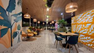 a restaurant with tables and chairs and potted plants at VICTORIA COLOR Hotel in Tacna