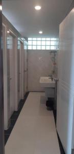 a white bathroom with a sink and a mirror at Ceniq Hotel in Lampang