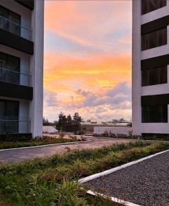 an empty street in front of a building with a sunset at Oderm one bedroom apartment in Syokimau near jkia airport and sgr station in Nairobi in Nairobi