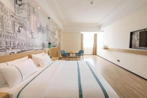 une chambre avec un grand lit et une table dans l'établissement City Comfort Inn Changning Wangchao, à Changning