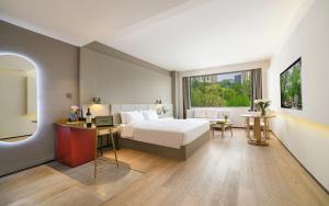 深セン市にあるXW Hotel (Shenzhen OCT)のベッドと机と窓のある寝室