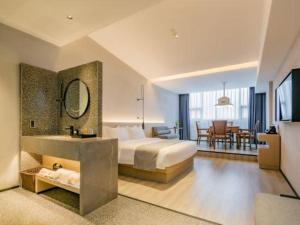 a hotel room with a bed and a dining room at Airfeel Hotel in Ziyang