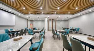 une salle de conférence avec des tables et des chaises et un tableau blanc dans l'établissement GYA Hotel Heze Zhonghua Road Jiahe Plaza, à Heze