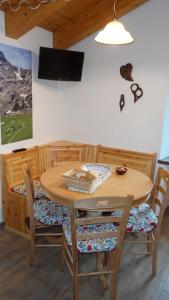 Una mesa de comedor con sillas y una mesa de madera. en La Luge, en Saint-Christophe