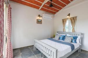 TalaiLakeside ParadisePrivate Pool3 CottagesLawn的卧室里有一张白色的床和蓝色的枕头