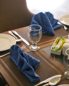 a wooden table with plates and a wine glass on it at Faletti's Express Hotel Airport Lahore in Lahore