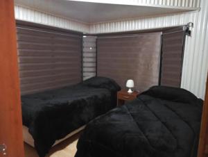 um quarto com duas camas e uma janela em Hostal Aurora Coronel em Concepción