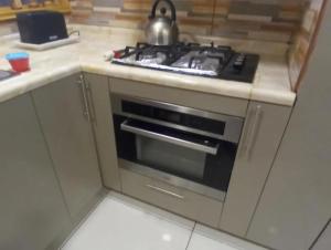 uma cozinha com um forno e uma chaleira em cima em Hostal Aurora Coronel em Concepción