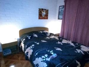 uma cama com um edredão num quarto em Hostal Aurora Coronel em Concepción