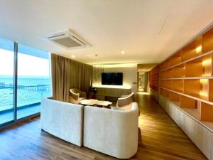 a hotel room with a couch and a table and a television at Symphony of The Sea Hotel in Ban Thai Don (2)