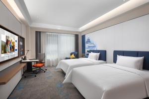Una habitación de hotel con dos camas y un televisor de pantalla plana. en 北京传媒大学希尔顿欢朋酒店Hampton by Hilton Beijing Communication University, en Beijing
