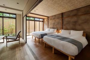 Un dormitorio con dos camas y una gran ventana. en Suiki Machiya House, en Kanazawa 60 fotos más