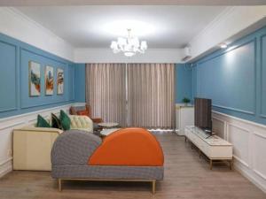 Una sala de estar con un sofá y un televisor. en Golden Diamond Hotel Zhongshan, en Zhongshan