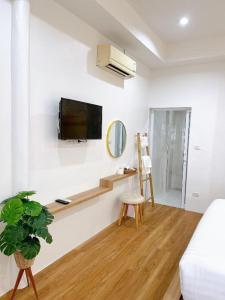 ein Wohnzimmer mit einem Fernseher an einer weißen Wand in der Unterkunft Coral Resort in Ko Chang