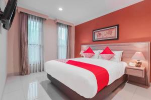 a bedroom with a large bed with red walls at Sriwijaya Hotel in Jakarta