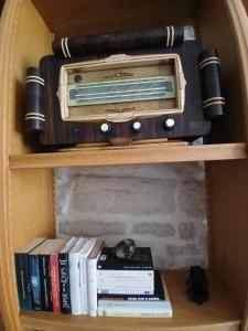 a book shelf with a radio and books at La Parenthèse Comtoise in Dole