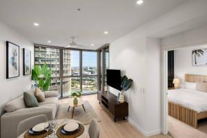 ブリスベンにあるLuxury 1BR in Queens Wharfのベッドとソファのあるリビングルーム