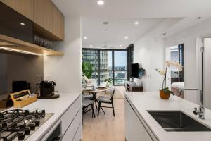 ブリスベンにあるLuxury 1BR in Queens Wharfのキッチン(コンロ付)、ダイニングルーム