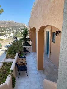 a patio with two benches and a building at Studio Saroukos in Kalymnos