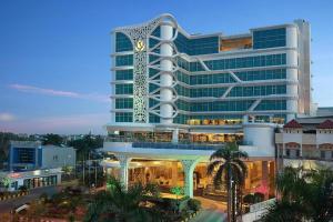 a large building with a clock on the side of it at Golden Tulip Galaxy Hotel Banjarmasin in Benuaanyar