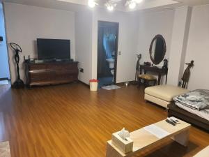a living room with a couch and a television in it at Samojeong, Jeju in Jeju