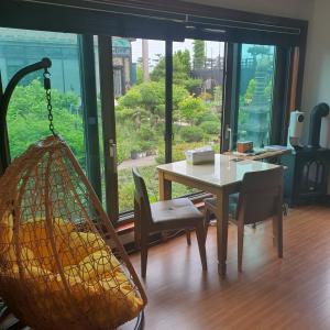 comedor con hamaca, mesa y sillas en Samojeong, Jeju, en Jeju