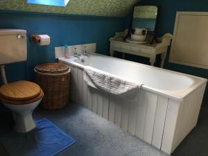 a bathroom with a tub and a toilet and a sink at Cotswolds Mine Hill House in Lower Brailes