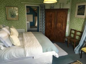 een slaapkamer met een groot bed en een stoel bij Cotswolds Mine Hill House in Lower Brailes