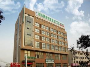 a building with a sign on the top of it at GreenTree Inn Lianyungang Guanyun Bus Station Zhenxing Garden Express Hotel in Guanyun