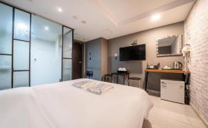 um quarto com uma grande cama branca e uma cozinha em Hotel TreeShade Dongdaemun em Seul