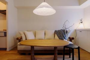 東京にあるThe Apartment Hotel 恵比寿1のテーブルとソファのあるリビングルーム