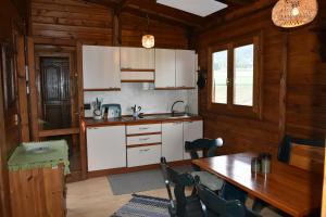 a kitchen with white cabinets and a table with chairs at Haus am See in Mühldorf