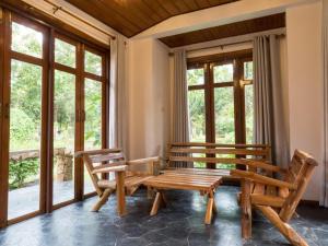 2 panche in legno in una camera con finestre di Khao Yai Country Hill Resort a Ban Na Sok