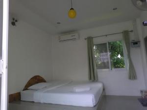 a white bedroom with a bed and a window at White Rock Resort Pakchong in Ban Nong Ka Cha