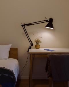 東京にあるThe Apartment Hotel 恵比寿1のベッドの横にランプ付きのデスク
