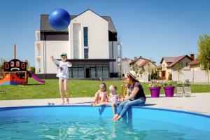 a woman and two children sitting in the water in a pool at Apartamenty Rodzinne Plater74 in Darłowo