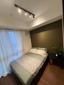 une chambre avec un lit et une fenêtre dans l'établissement NFr, à Manille