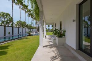 un couloir vide d'un immeuble avec une pelouse et des palmiers dans l'établissement Beachfront Villa in Bali, à Cemagi