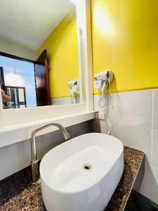 um banheiro com pia branca e espelho em Alice in Wonderland Beach Hotel em Boracay