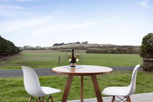 a table with two chairs and a bottle of wine at Bimbadeen Phillip Island Farm Retreats in Ventnor