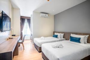 une chambre d'hôtel avec deux lits et un bureau dans l'établissement XOTEL, à Ban Non Muang 56 autres photos