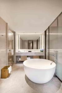 a large white bath tub in a bathroom at Derayco Hotel Foshan in Shunde