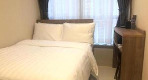 Uma cama ou camas num quarto em WE Hotel Kowloon