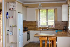 una cucina con mobili bianchi e un frigorifero bianco di Lila view a Qeparo