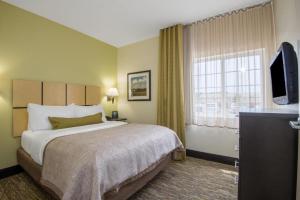 una camera d'albergo con un letto e una televisione di Candlewood Suites Jefferson City By IHG a Jefferson City Altre 42 foto