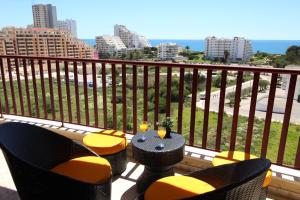 einen Balkon mit einem Tisch und Stühlen sowie Stadtblick in der Unterkunft Club Praia Mar in Portimão