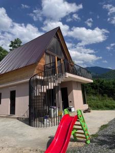 une aire de jeux en face d'une maison avec toboggan dans l'établissement Villa Cottage Merisi, à Inasharidzeebi