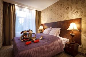 dos animales de peluche sentados en una cama en un dormitorio en BridgeStoneLuxApart Free Parking, en Riga