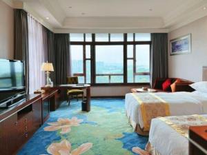 a hotel room with two beds and a flat screen tv at Xinjin Celebrity City Hotel in Xinjin